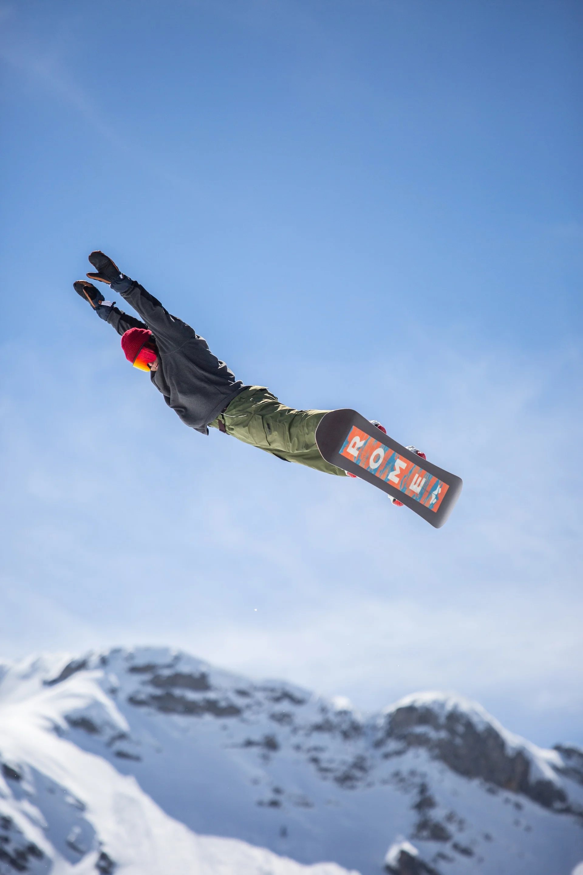 Snowboarder doing a big jump on a Rome snowboard